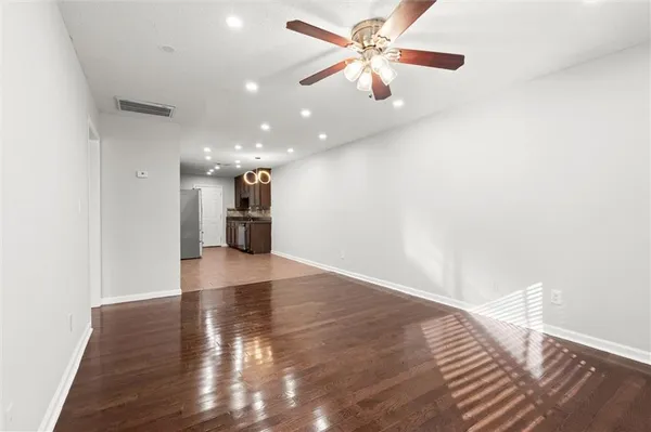 a view of an empty room with wooden floor