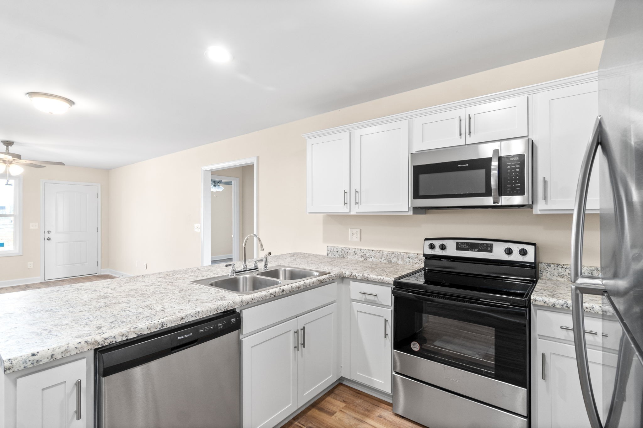 9550 Russellville Road, Unit C Guthrie, KY 42234 - Photo 7 of 23 a kitchen with stainless steel appliances granite countertop a sink dishwasher stove and microwave with wooden cabinets