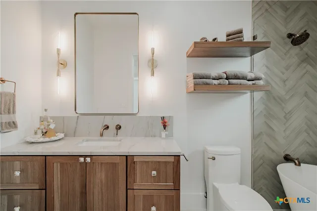 a bathroom with a sink a toilet and shower