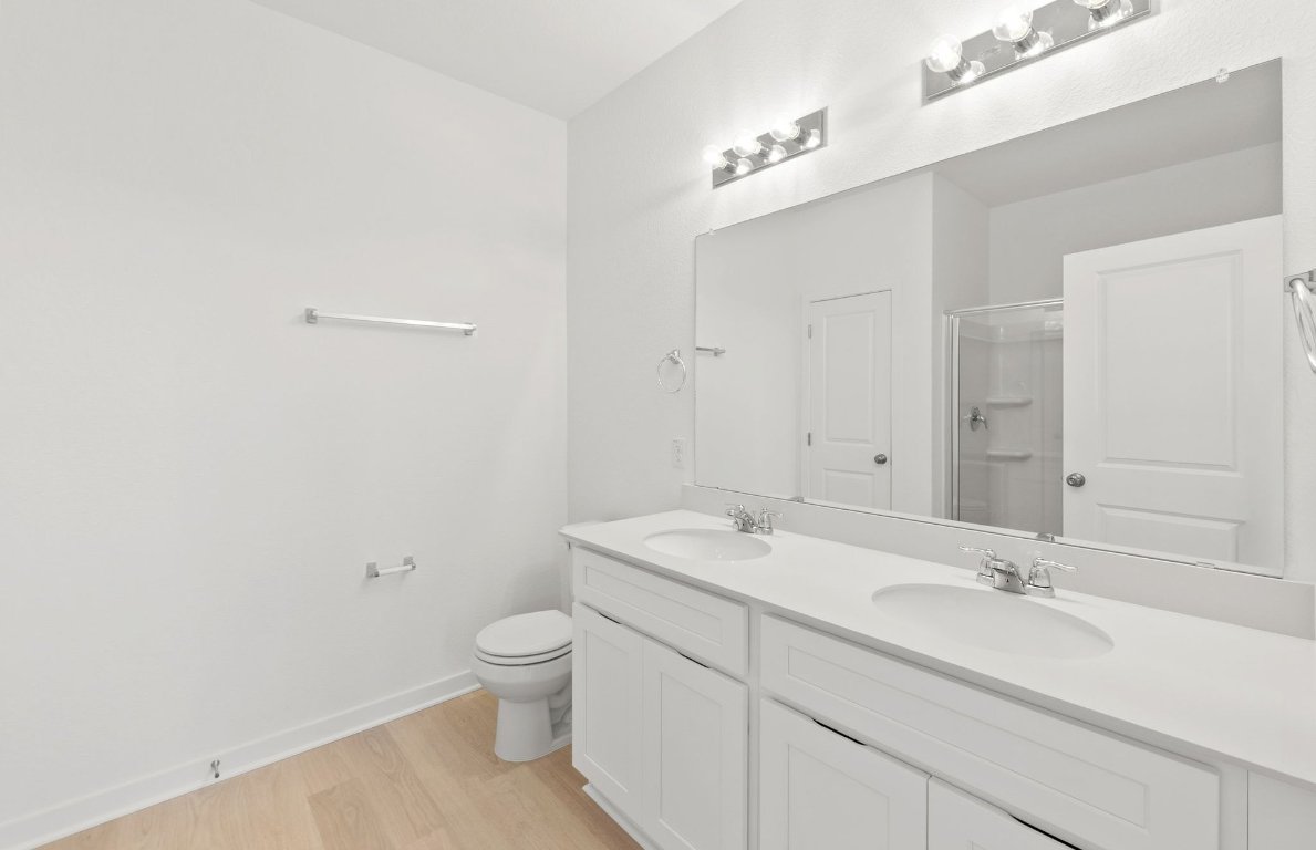 404 Sullivan Way Elgin, TX 78621 - Photo 16 of 23 a bathroom with a sink a toilet and a large mirror