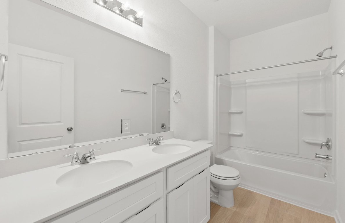 404 Sullivan Way Elgin, TX 78621 - Photo 19 of 23 a bathroom with a bathtub shower sink vanity mirror and toilet