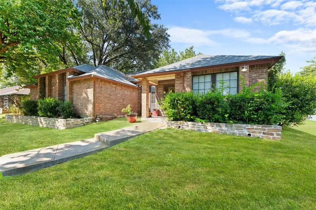a front view of a house with a yard and trees