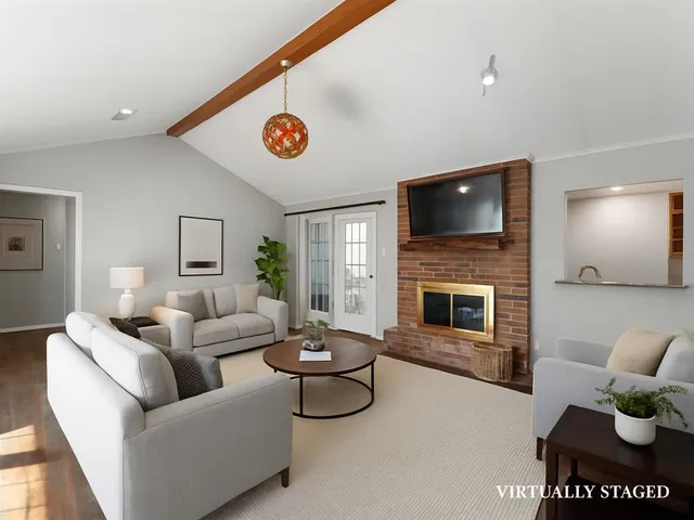 a living room with furniture a flat screen tv and a fireplace