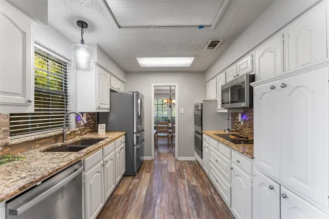 a kitchen with stainless steel appliances granite countertop a sink stove and refrigerator