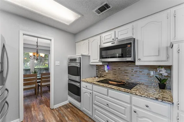 a kitchen with granite countertop a refrigerator stove and microwave