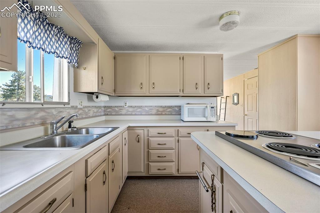 332 Valley Circle Guffey, CO 80820 - Photo 17 of 32 a kitchen with cabinets appliances a sink and a window