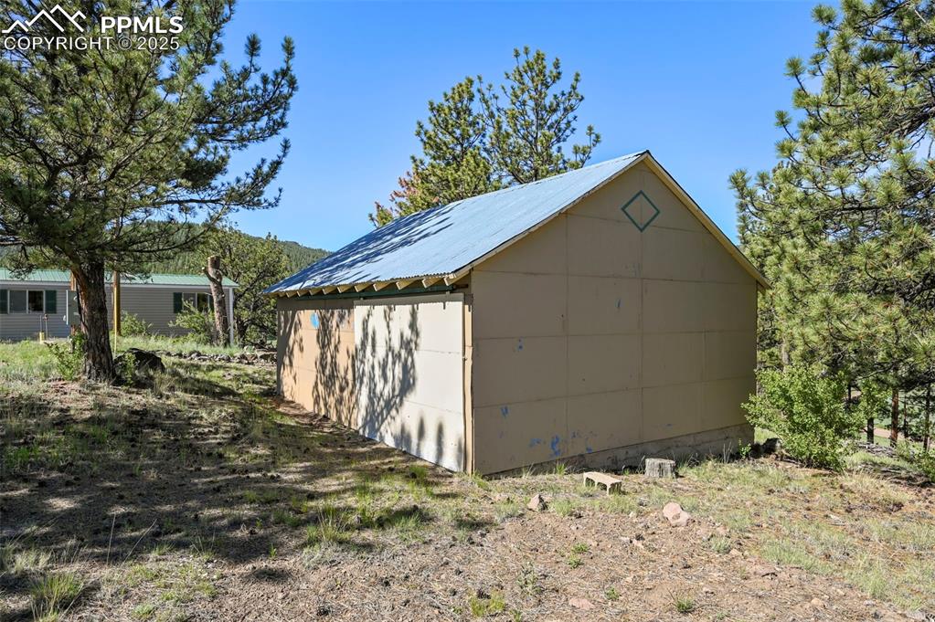 332 Valley Circle Guffey, CO 80820 - Photo 27 of 32 a backyard of a house with large trees and wooden fence