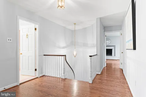 an empty room with wooden floor a fireplace and windows