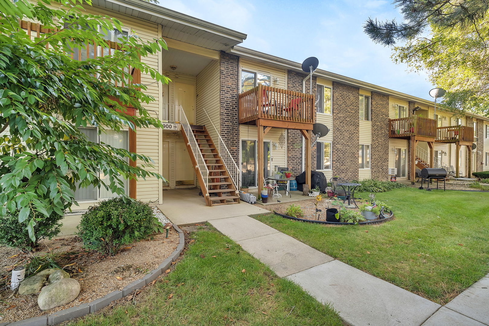 1900 Light Road, Unit 202 Oswego, IL 60543 - Photo 15 of 15 a front view of a house with a garden and plants