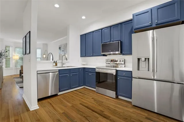 a kitchen with a refrigerator cabinets and wooden floor