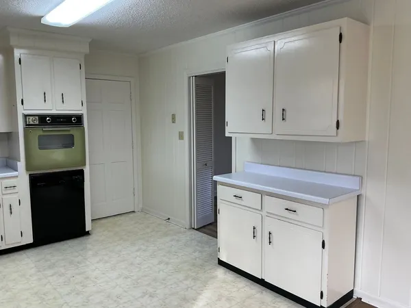 a kitchen with white cabinets and a refrigerator