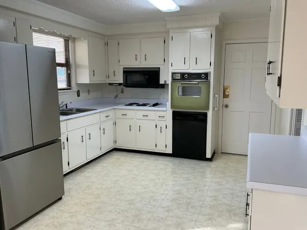 a kitchen with stainless steel appliances a refrigerator sink and cabinets