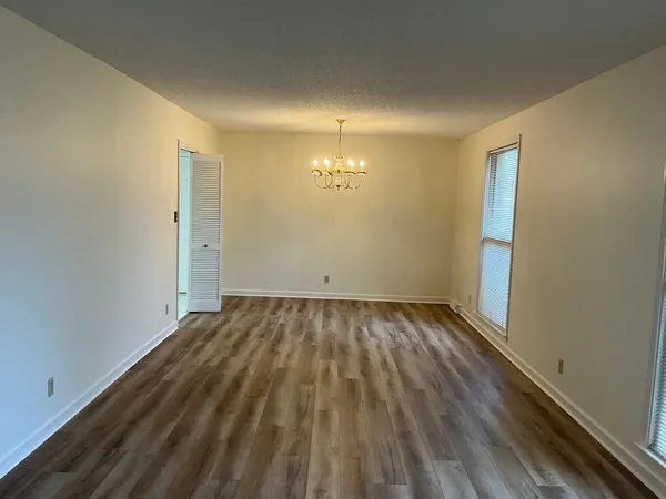 a view of an empty room and chandelier fan