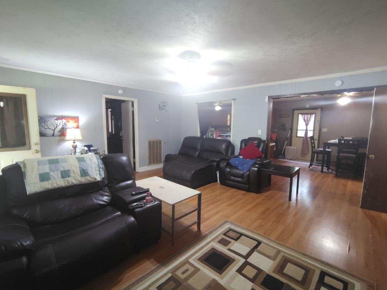 1475 Authur Byrd Road Pocahontas, TN 38061 - Photo 21 of 37 Living area featuring light wood-finish flooring, light gray wall paneling, and an open doorway leading to an adjacent room