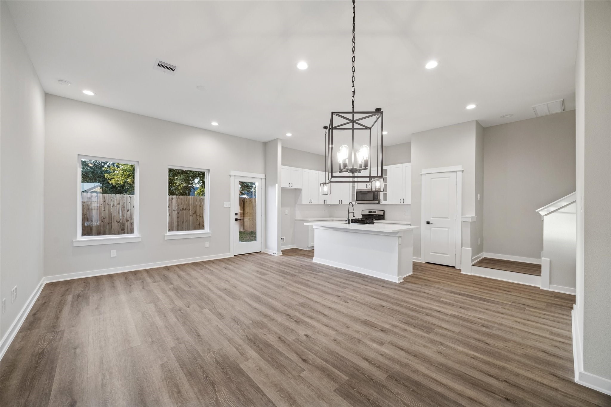 11307 Stonework Grove Lane Houston, TX 77076 - Photo 36 of 46 a large kitchen with kitchen island a stove a sink dishwasher and a refrigerator with wooden floor
