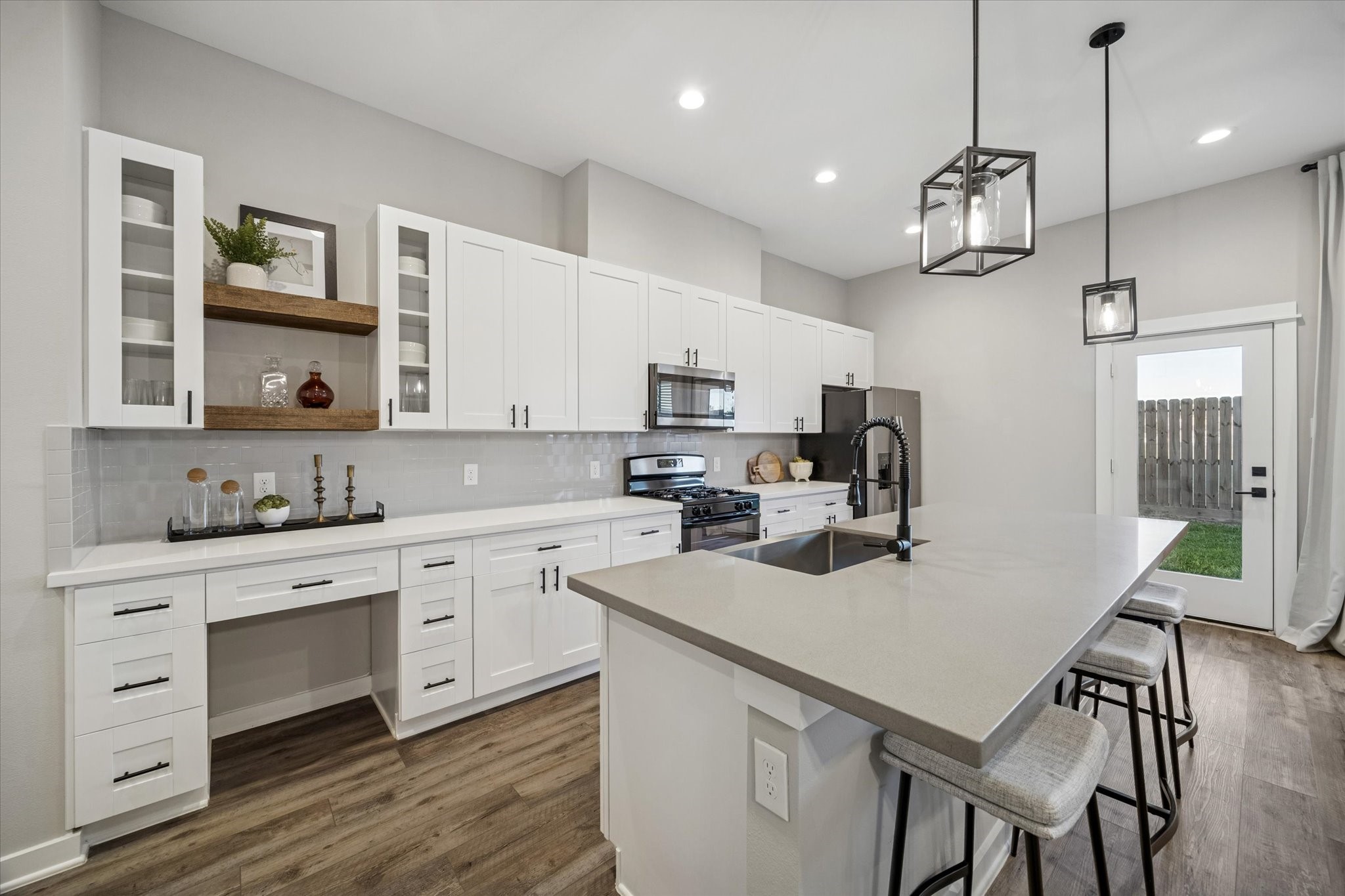 11307 Stonework Grove Lane Houston, TX 77076 - Photo 9 of 46 a kitchen with a center island white cabinets and stainless steel appliances