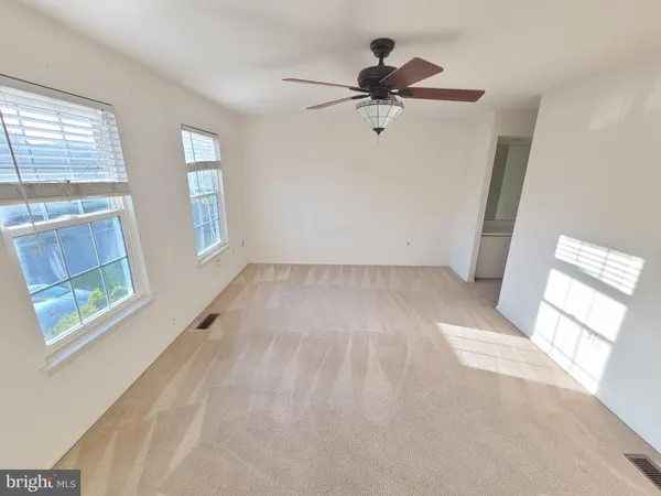 a view of empty room with windows and fan