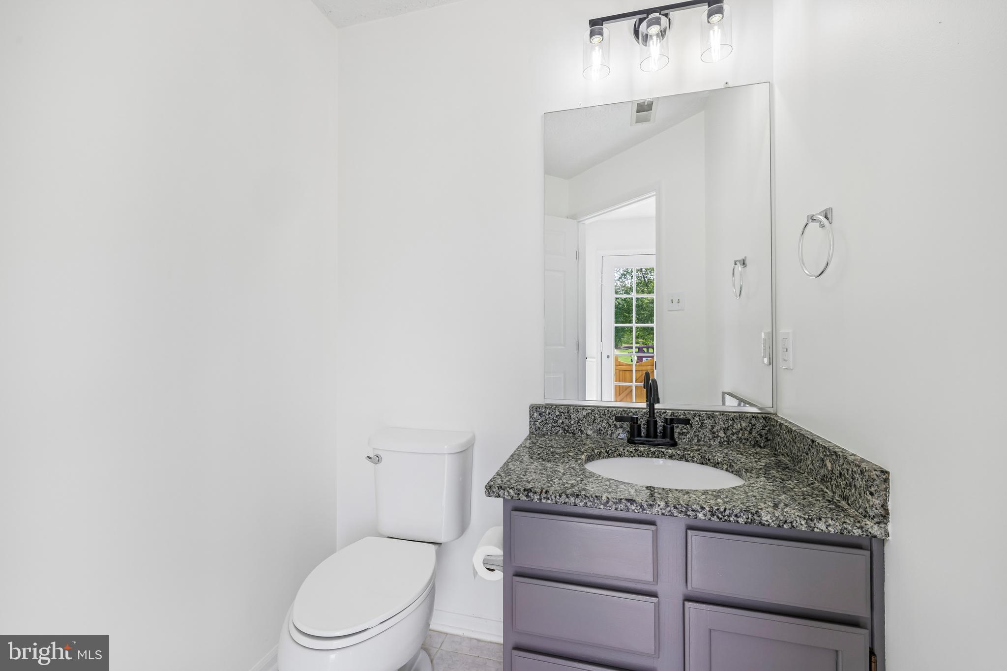 5243 Regal Court Frederick, MD 21703 - Photo 13 of 27 a bathroom with a granite countertop sink toilet and mirror