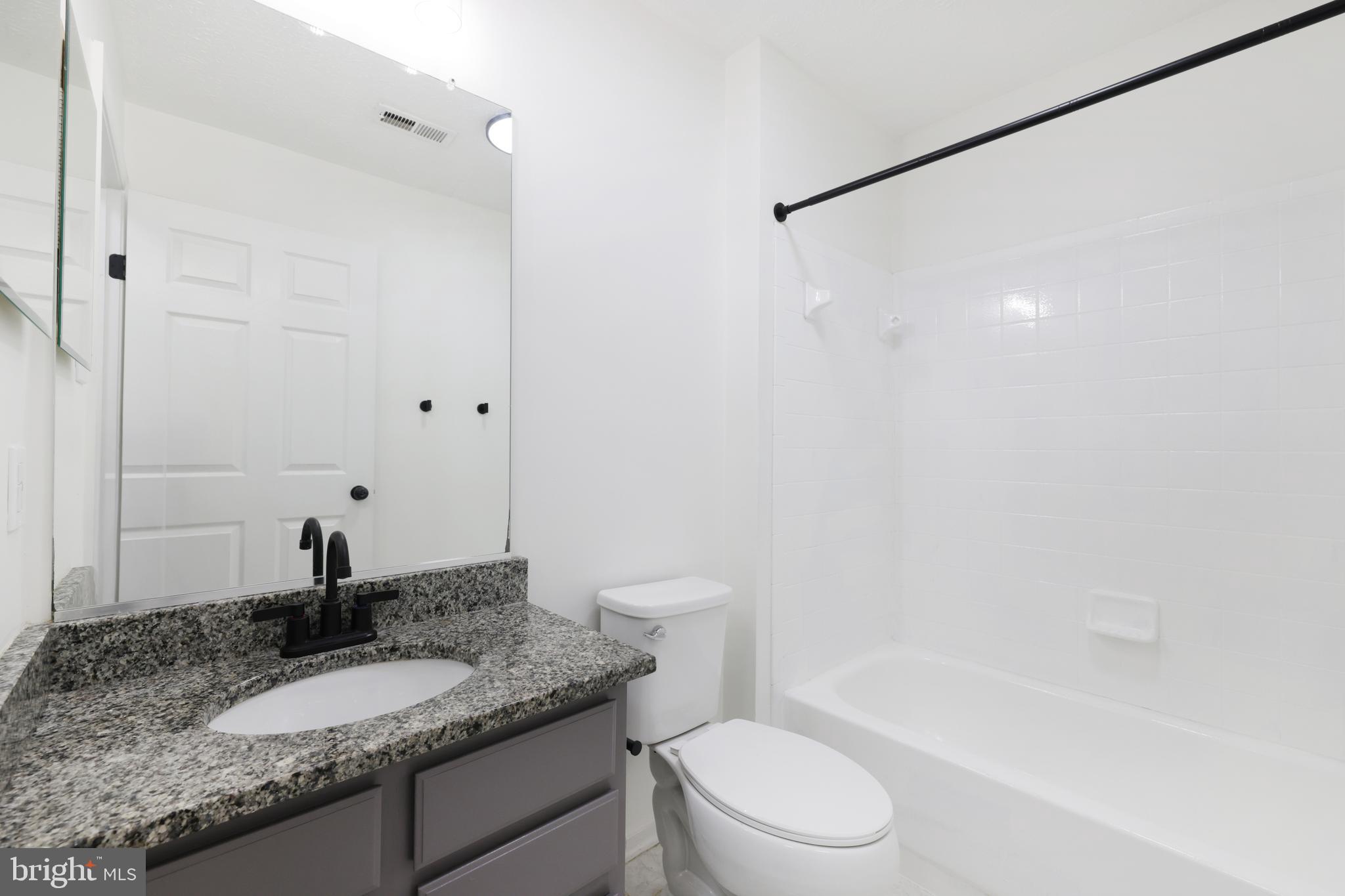 5243 Regal Court Frederick, MD 21703 - Photo 22 of 27 a bathroom with a granite countertop sink toilet and shower