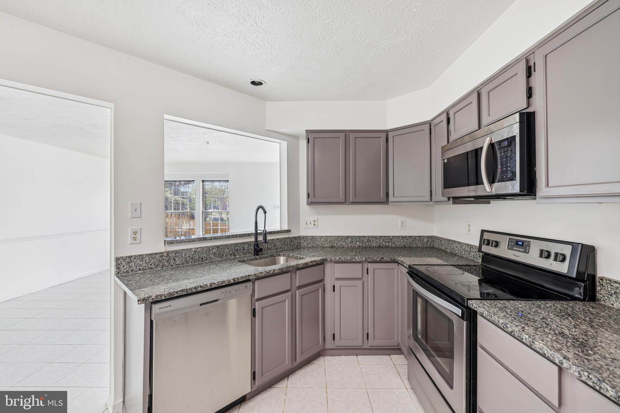 5243 Regal Court Frederick, MD 21703 - Photo 10 of 27 a kitchen with stainless steel appliances granite countertop a sink stove and microwave