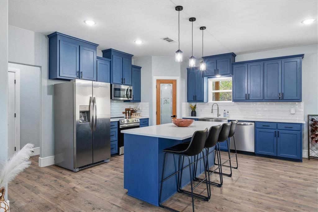 1159 Highway 276 Emory, TX 75440 - Photo 6 of 39 a kitchen with granite countertop a center island stainless steel appliances and wooden cabinets