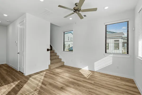 a view of an empty room with a window and wooden floor