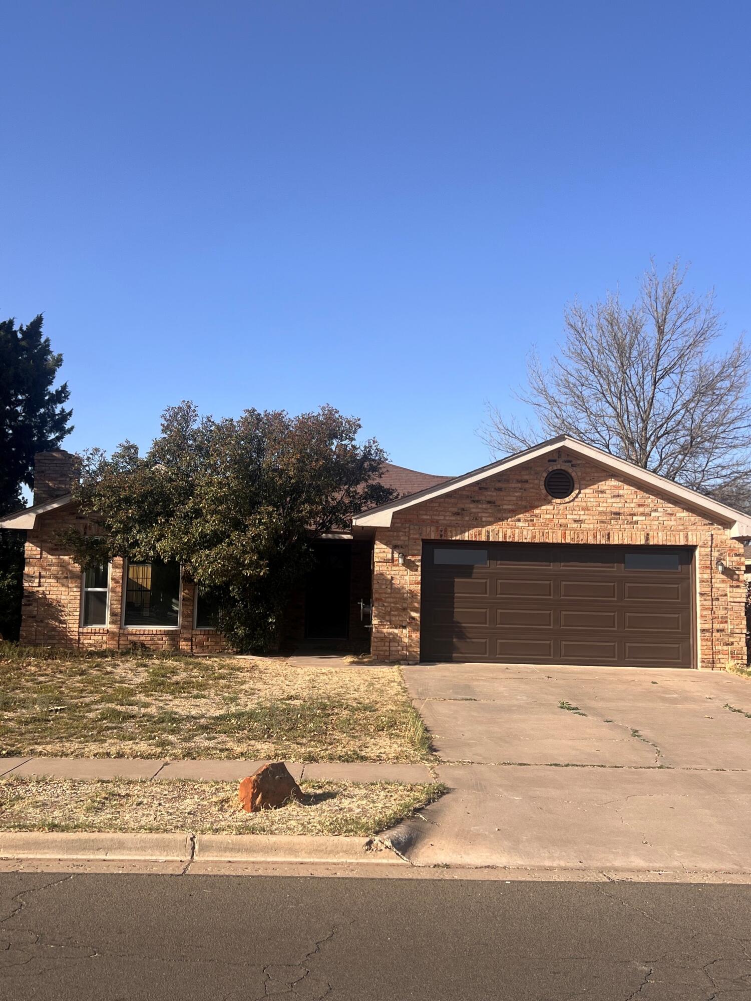 5718 95th Street Lubbock, TX 79424 - Photo 1 of 16 a front view of a house with a yard