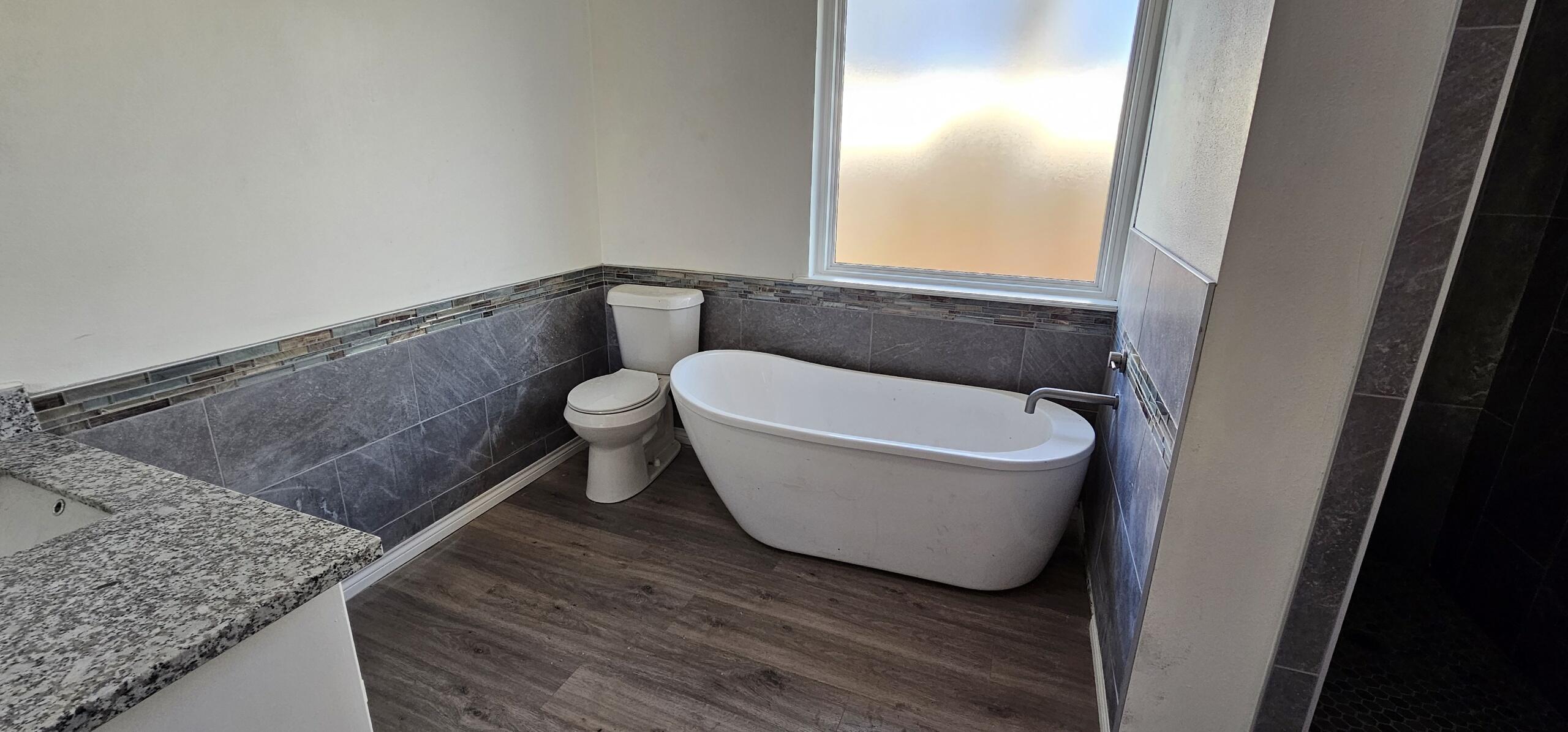 5718 95th Street Lubbock, TX 79424 - Photo 12 of 16 a bathroom with a bathtub and window