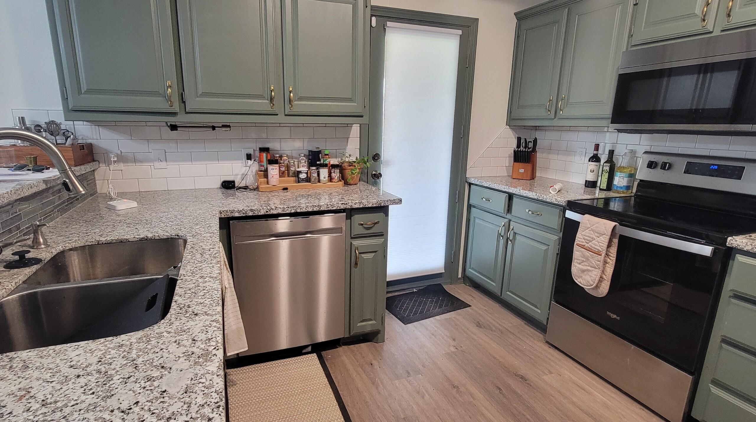 5718 95th Street Lubbock, TX 79424 - Photo 4 of 16 a kitchen with stainless steel appliances granite countertop a sink a stove a microwave and refrigerator