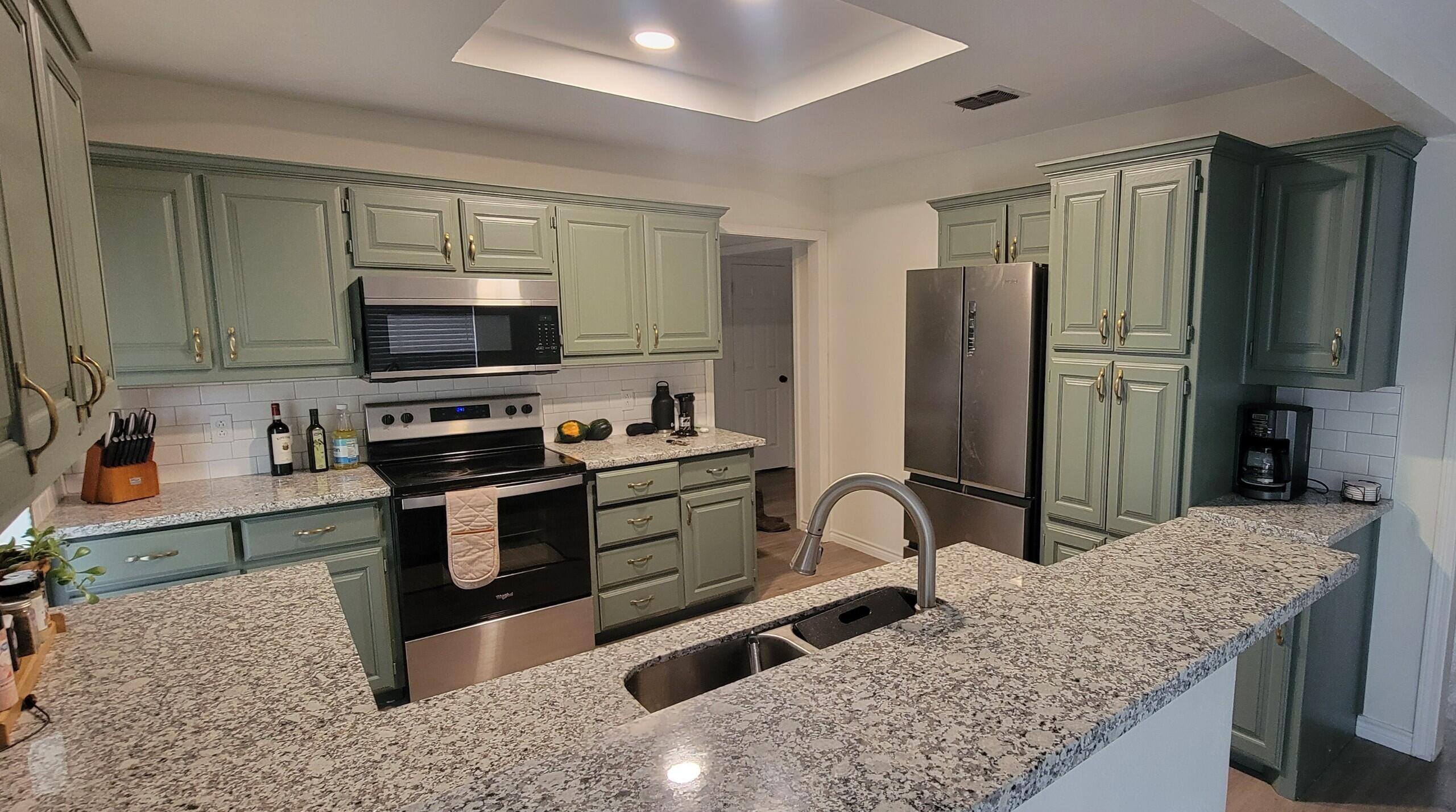5718 95th Street Lubbock, TX 79424 - Photo 5 of 16 a kitchen with stainless steel appliances granite countertop a sink stove and refrigerator
