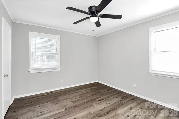 a view of empty room with wooden floor