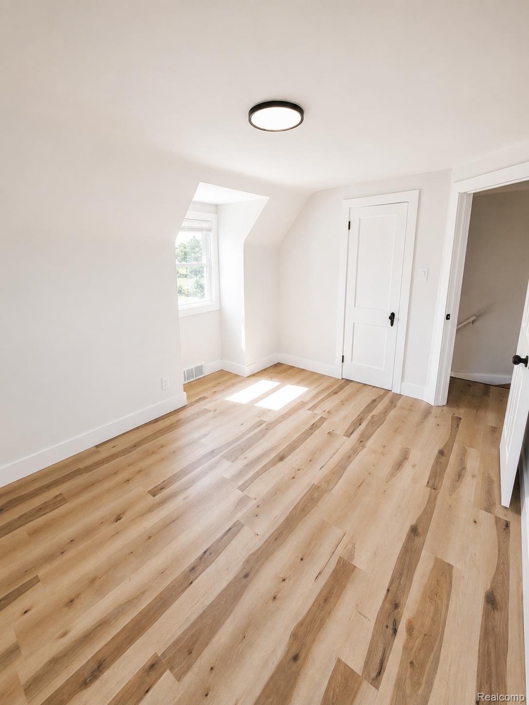 20024 Meyers Road Detroit, MI 48235 - Photo 10 of 16 Room featuring wide plank wood-finish flooring, white baseboards, and a contemporary flush-mount ceiling light