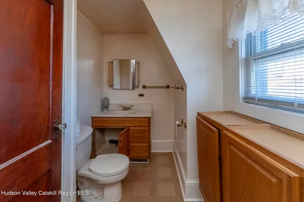 a bathroom with a sink toilet and window