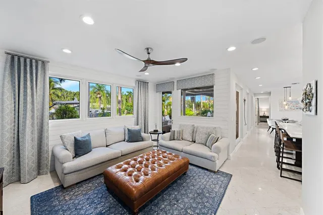 a living room with furniture flat screen tv and a large window