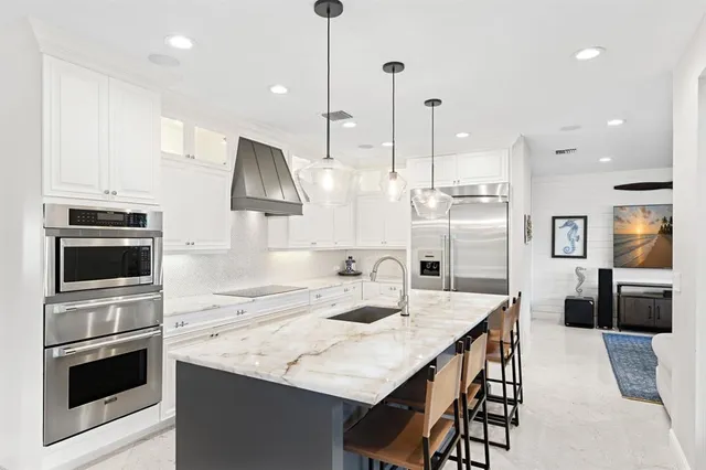 a kitchen with a dining table chairs sink and cabinets