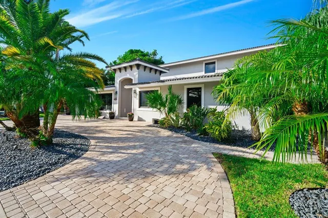 a front view of a house with a yard and potted plants