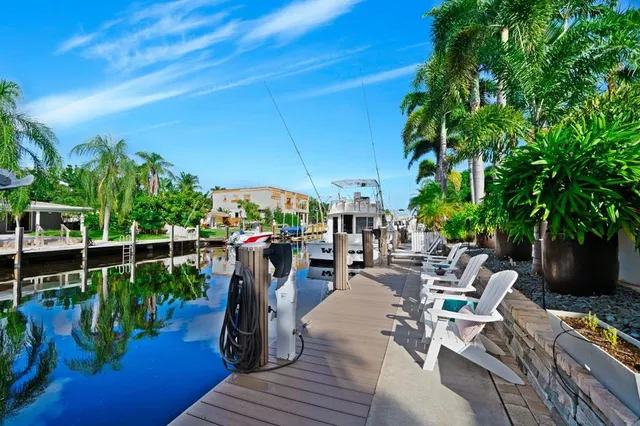 a view of a patio with table and chairs potted plants and floor to ceiling window