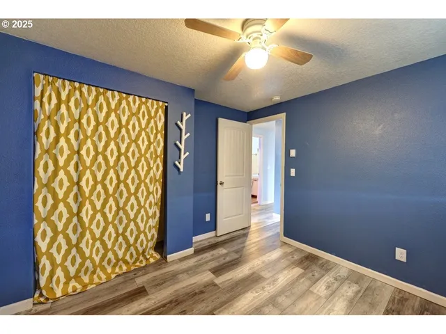 a view of an empty room and chandelier fan