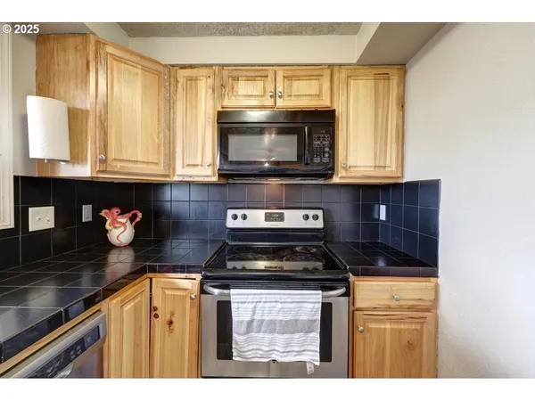 a kitchen with granite countertop a stove a sink and a microwave