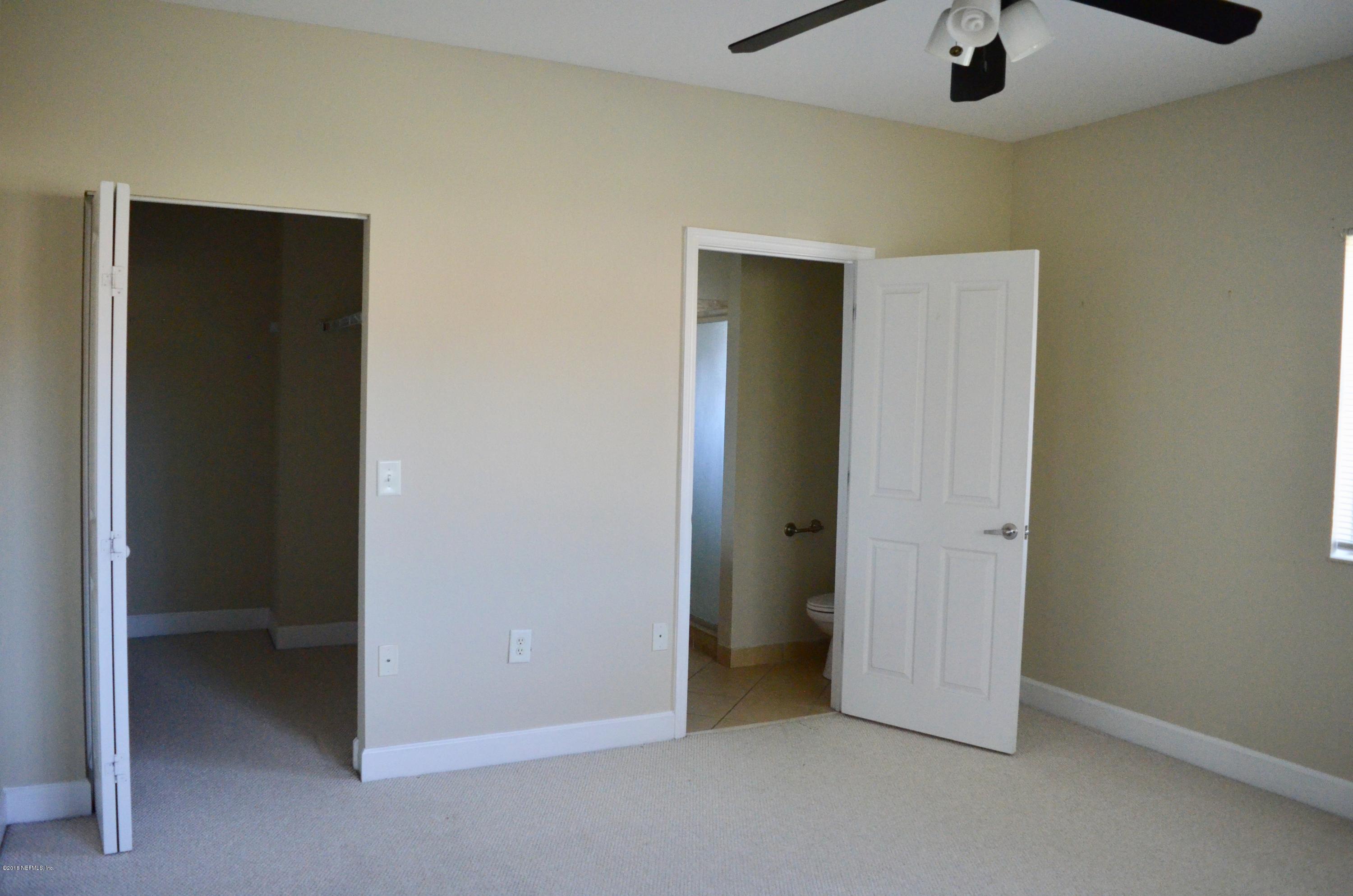 9745 Touchton Road, Unit 1821 Jacksonville, FL 32246 - Photo 22 of 33 an empty room with a closet and chandelier fan