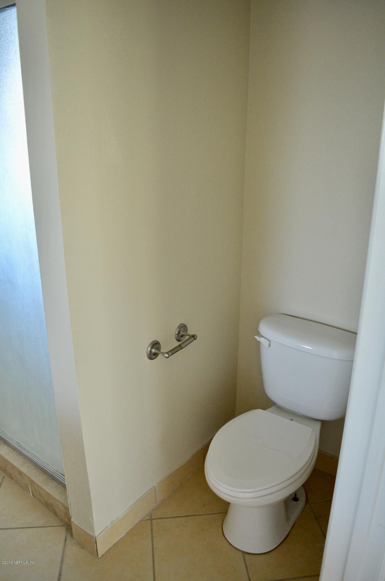 9745 Touchton Road, Unit 1821 Jacksonville, FL 32246 - Photo 24 of 33 a white toilet sitting next to a white sink and vanity
