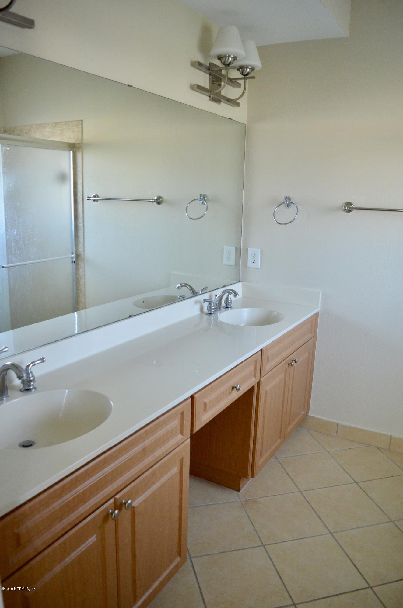 9745 Touchton Road, Unit 1821 Jacksonville, FL 32246 - Photo 25 of 33 a bathroom with a sink a vanity and a mirror