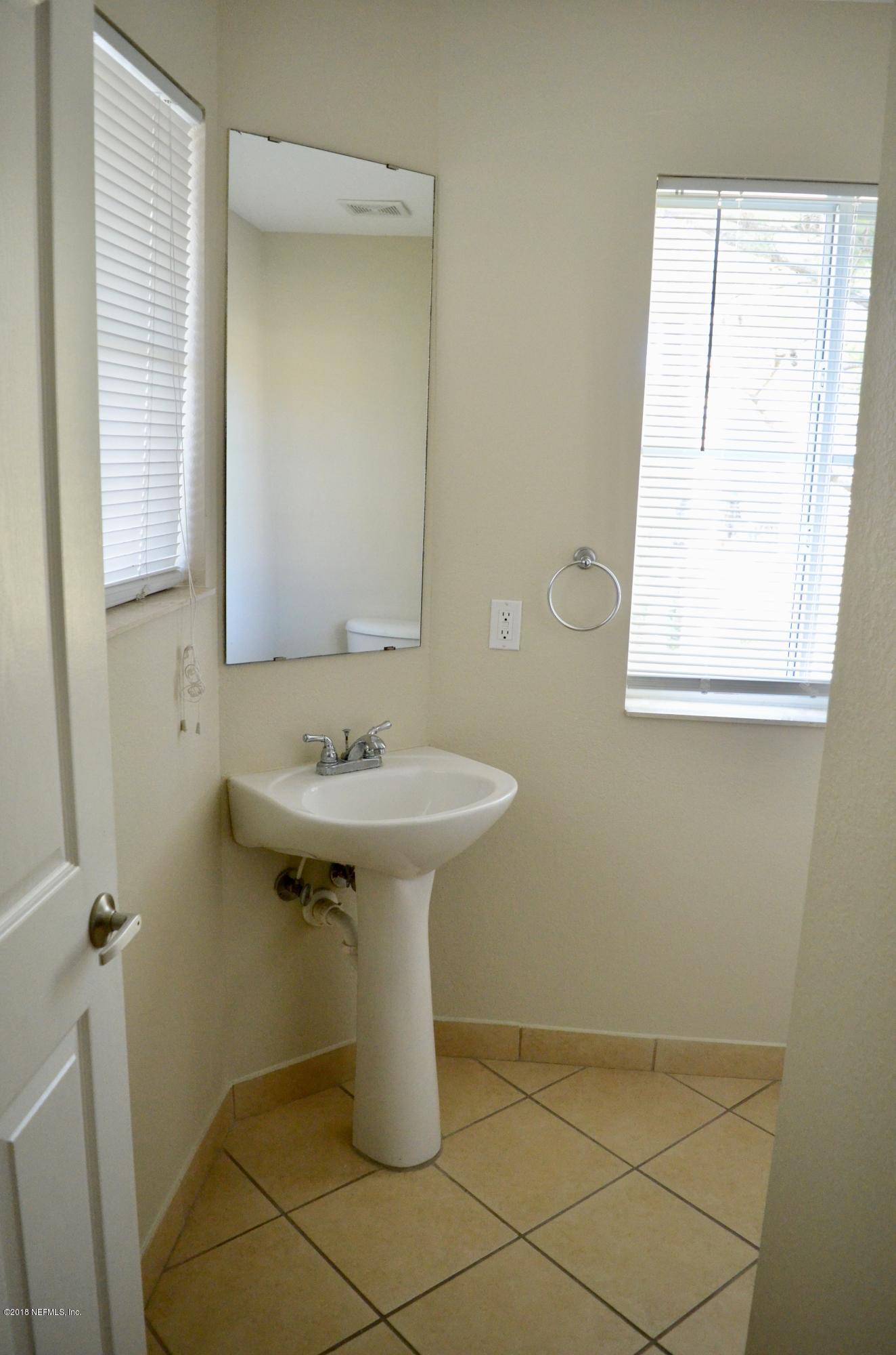 9745 Touchton Road, Unit 1821 Jacksonville, FL 32246 - Photo 4 of 33 a bathroom with a sink a mirror and a window