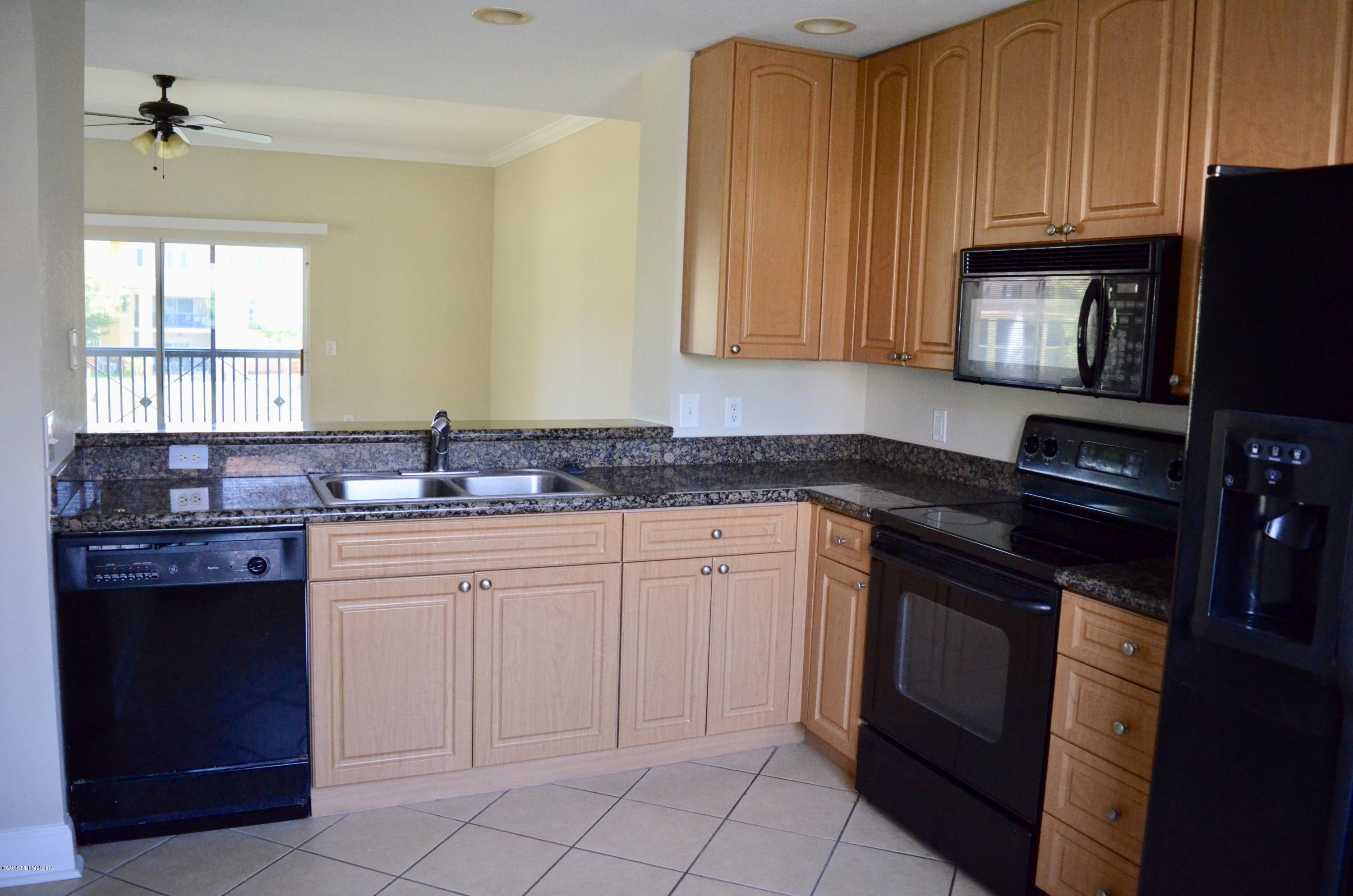 9745 Touchton Road, Unit 1821 Jacksonville, FL 32246 - Photo 6 of 33 a kitchen with granite countertop a sink cabinets and stainless steel appliances
