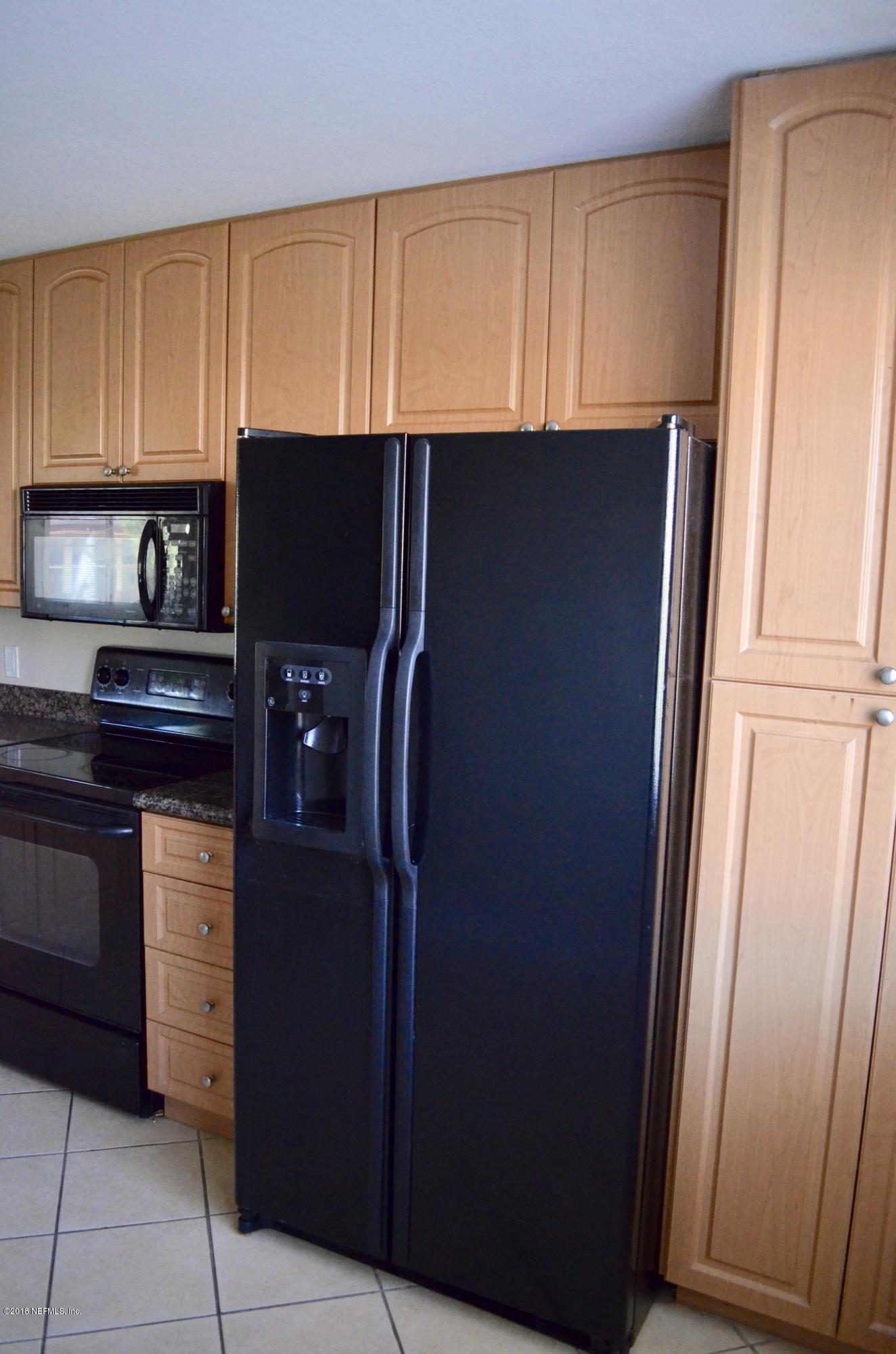 9745 Touchton Road, Unit 1821 Jacksonville, FL 32246 - Photo 7 of 33 a kitchen with stainless steel appliances granite countertop a refrigerator and a cabinets