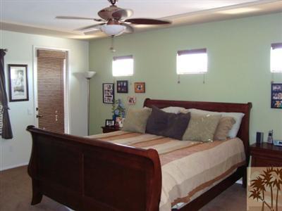 83285 Wagon Road Indio, CA 92203 - Photo 14 of 17 a bedroom with a large bed and a chandelier