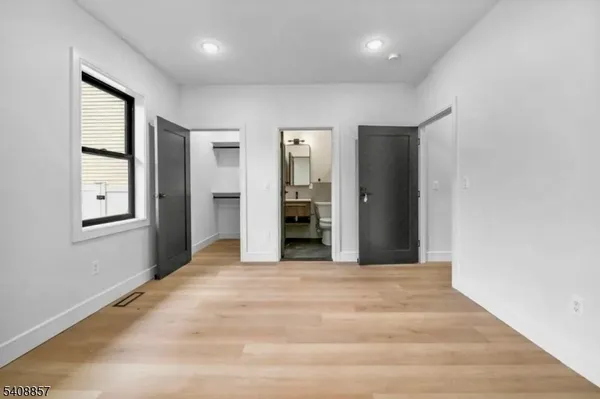 an empty room with windows and cabinet