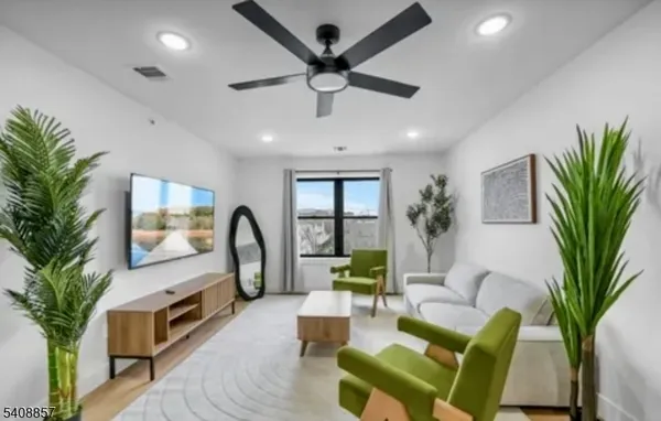 a living room with furniture a large window and a chandelier
