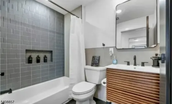 a bathroom with a sink toilet vanity and tub