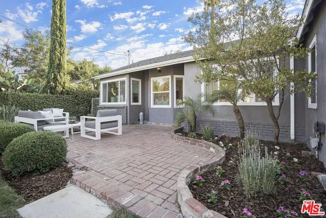 a living room with furniture a flat screen tv and a window